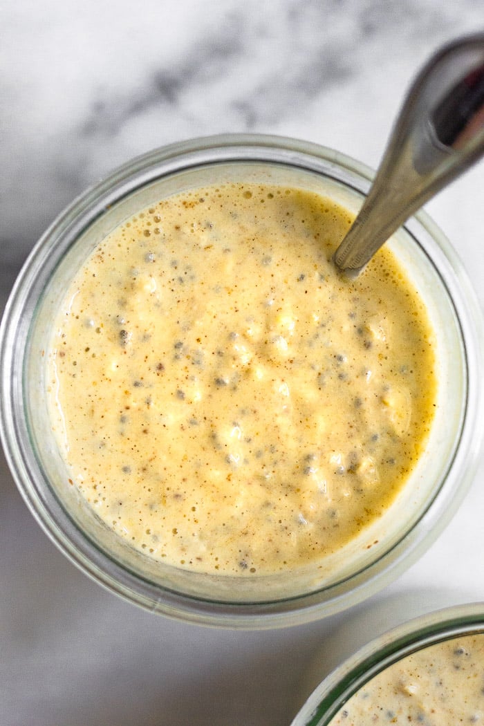 Overhead shot of healthy overnight oats with yogurt with a spoon coming out of it.