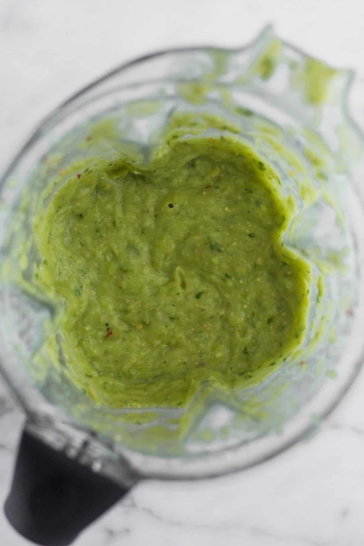 Blender filled with Roasted Tomatillo Avocado Salsa after it's been blended