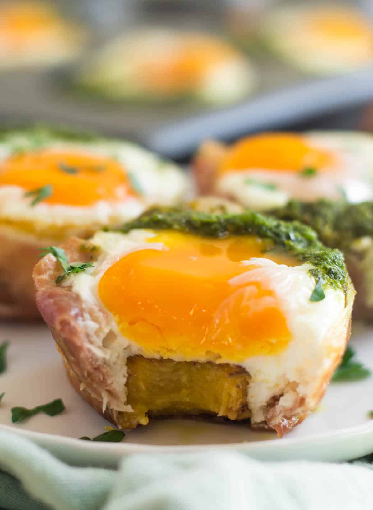 Close up of prosciutto egg cup with a bit taken out of it