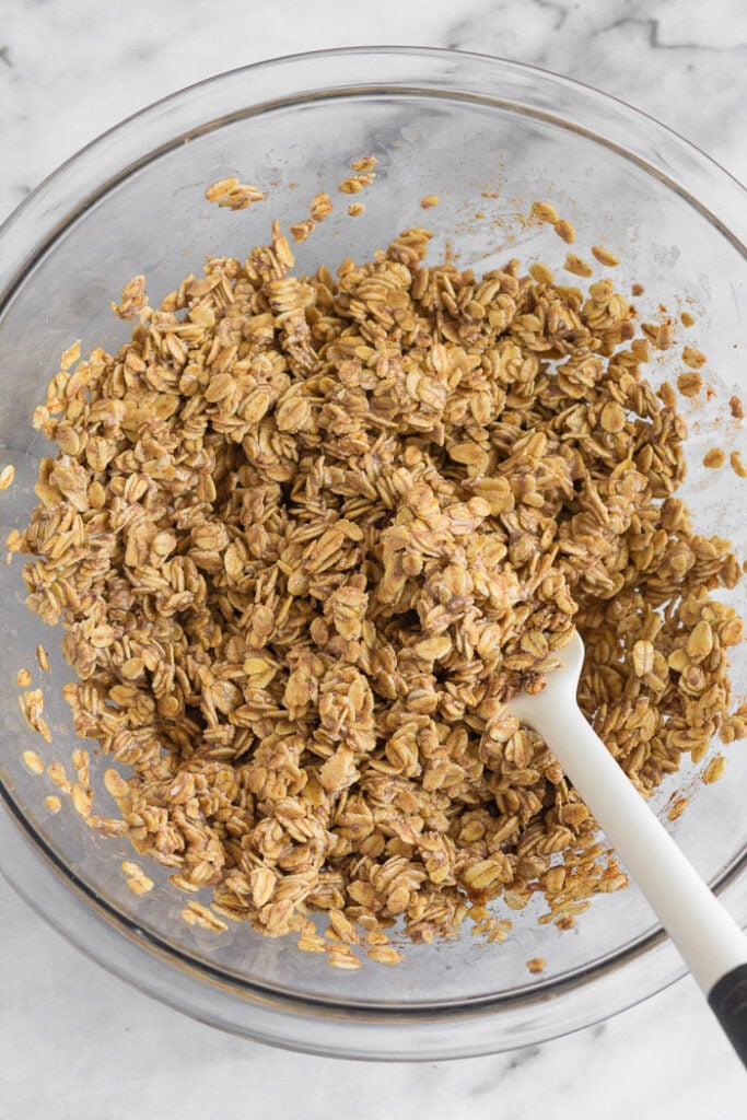 Large glass bowl of rolled oat mixture for muffins.