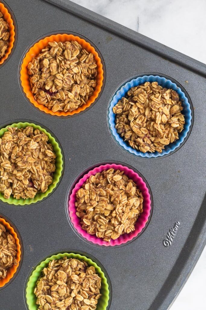 Overhead shot of silicone muffin liners filled with oatmeal cups before they are baked.