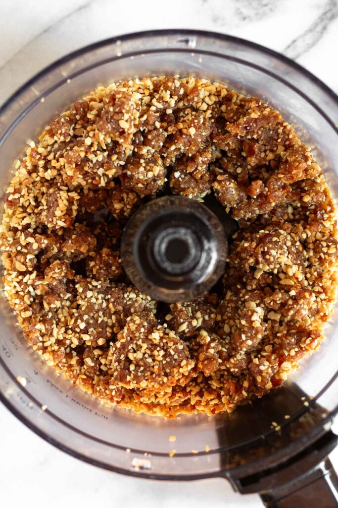 An overhead shot of date and nut mixture in a food processor.