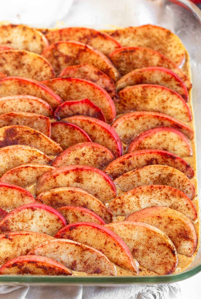 No bake apple bars in a glass baking dish sprinkled with cinnamon.