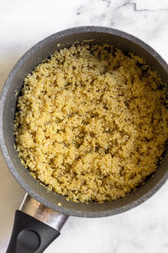Small saucepan filled with cooked quinoa.