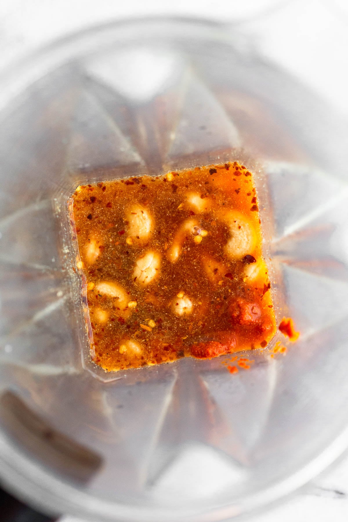 Blender filled with cashews, spices, water, and curry paste.