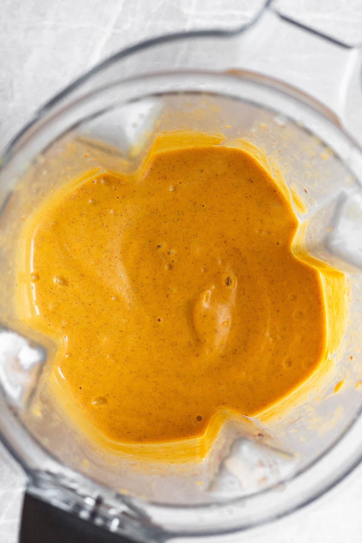 Blender filled with a creamy pumpkin mixture.
