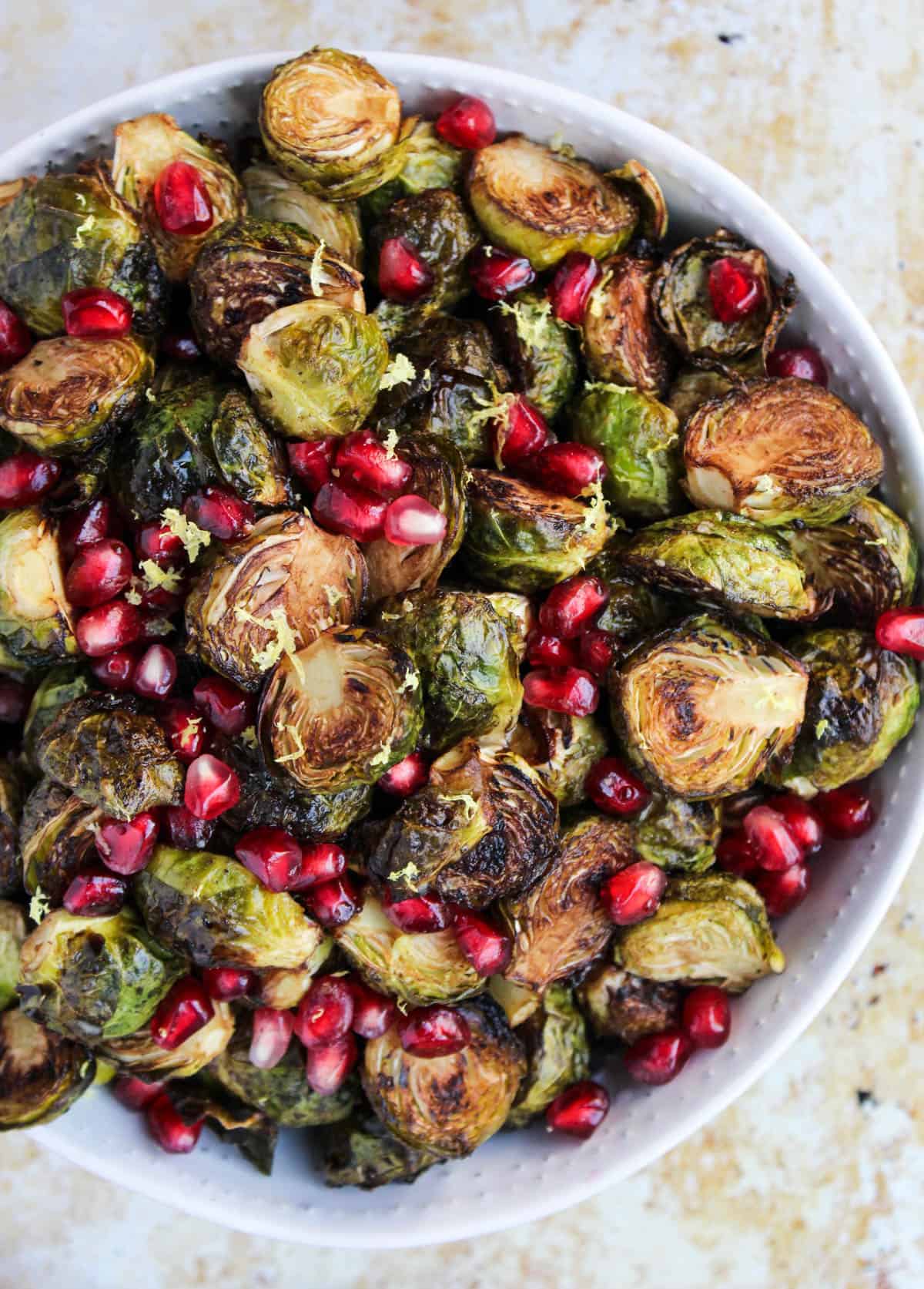 These Ginger & Balsamic Roasted Brussels Sprouts with Pomegranates are an easy & healthy side dish that are just as festive as the holiday season - Eat the Gains
