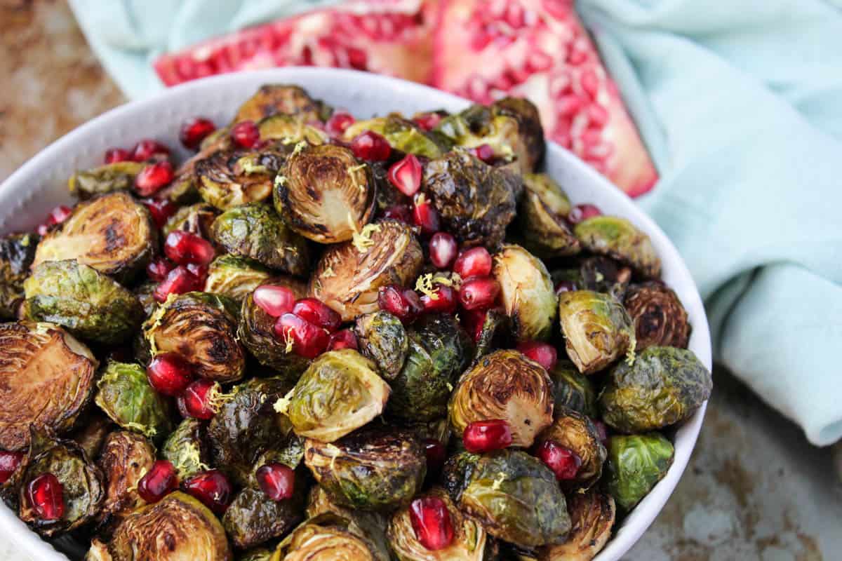 These Ginger & Balsamic Roasted Brussels Sprouts with Pomegranates are an easy & healthy side dish that are just as festive as the holiday season - Eat the Gains