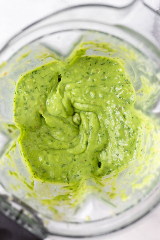 Overhead shot of avocado cilantro sauce in a blender.
