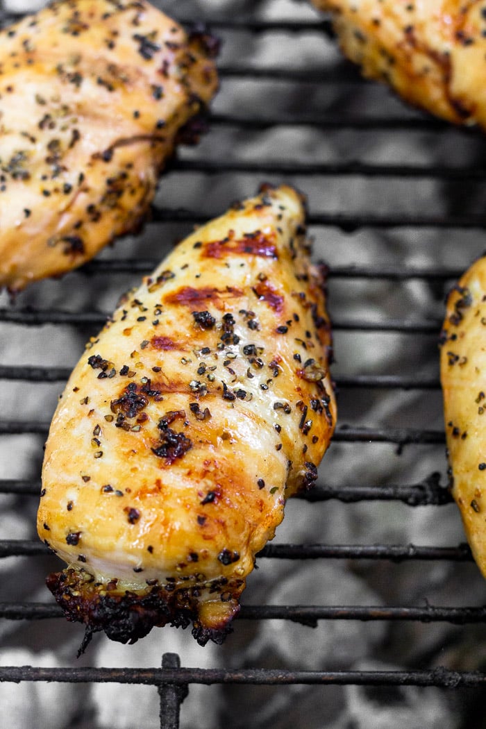Grilled lemon pepper chicken on a grill.