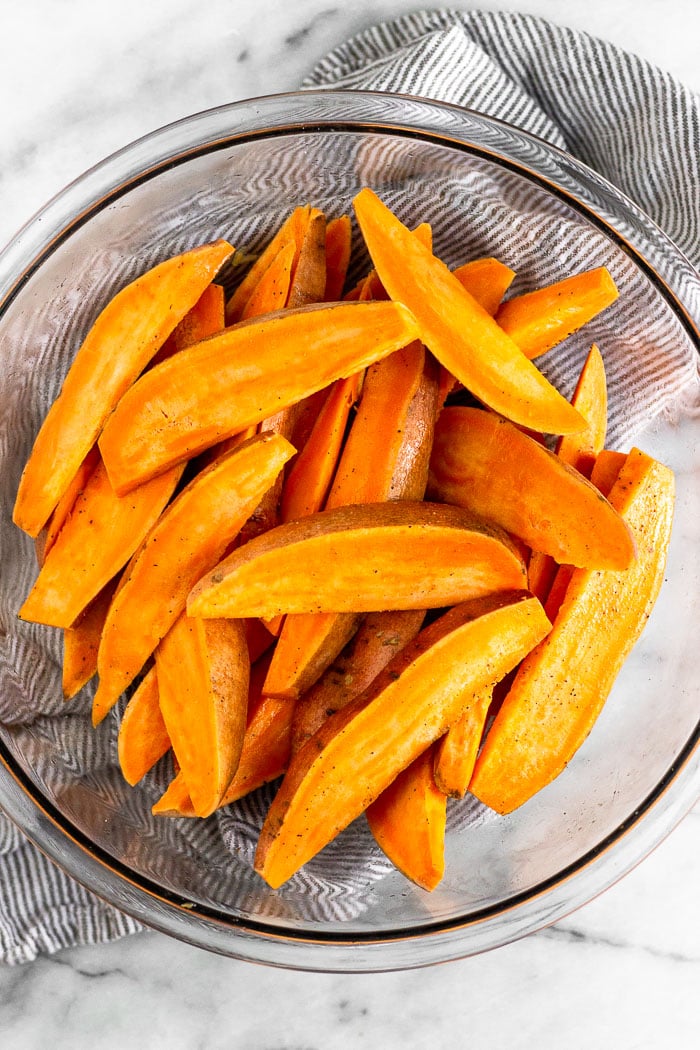 Glass bowl full of sweet potato wedges.