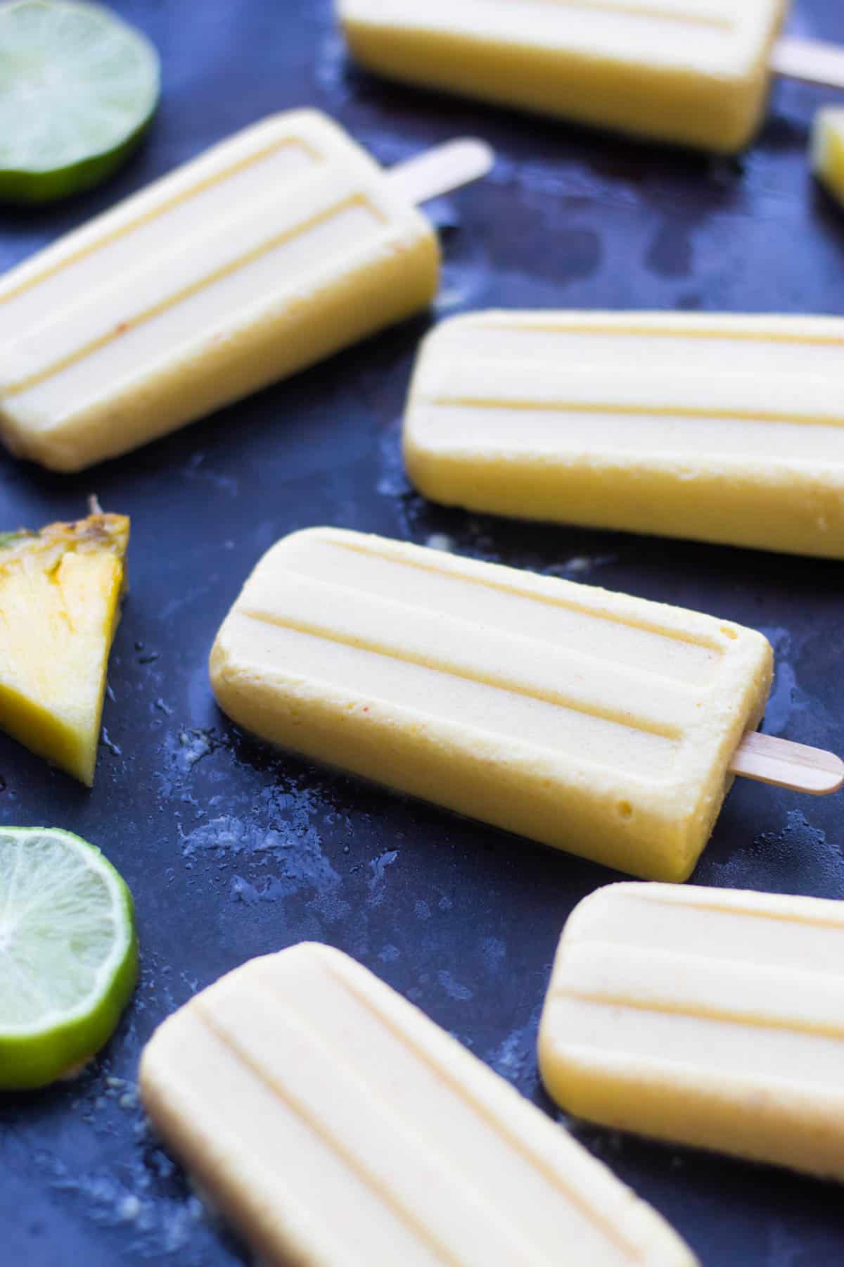 4 ingredient Pineapple Popsicles make an easy and healthy summertime treat. They are vegan, paleo, and sweetener free! - Eat the Gains