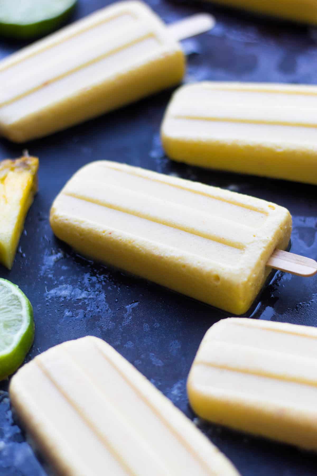 4 ingredient Pineapple Popsicles make an easy and healthy summertime treat. They are vegan, paleo, and sweetener free! - Eat the Gains