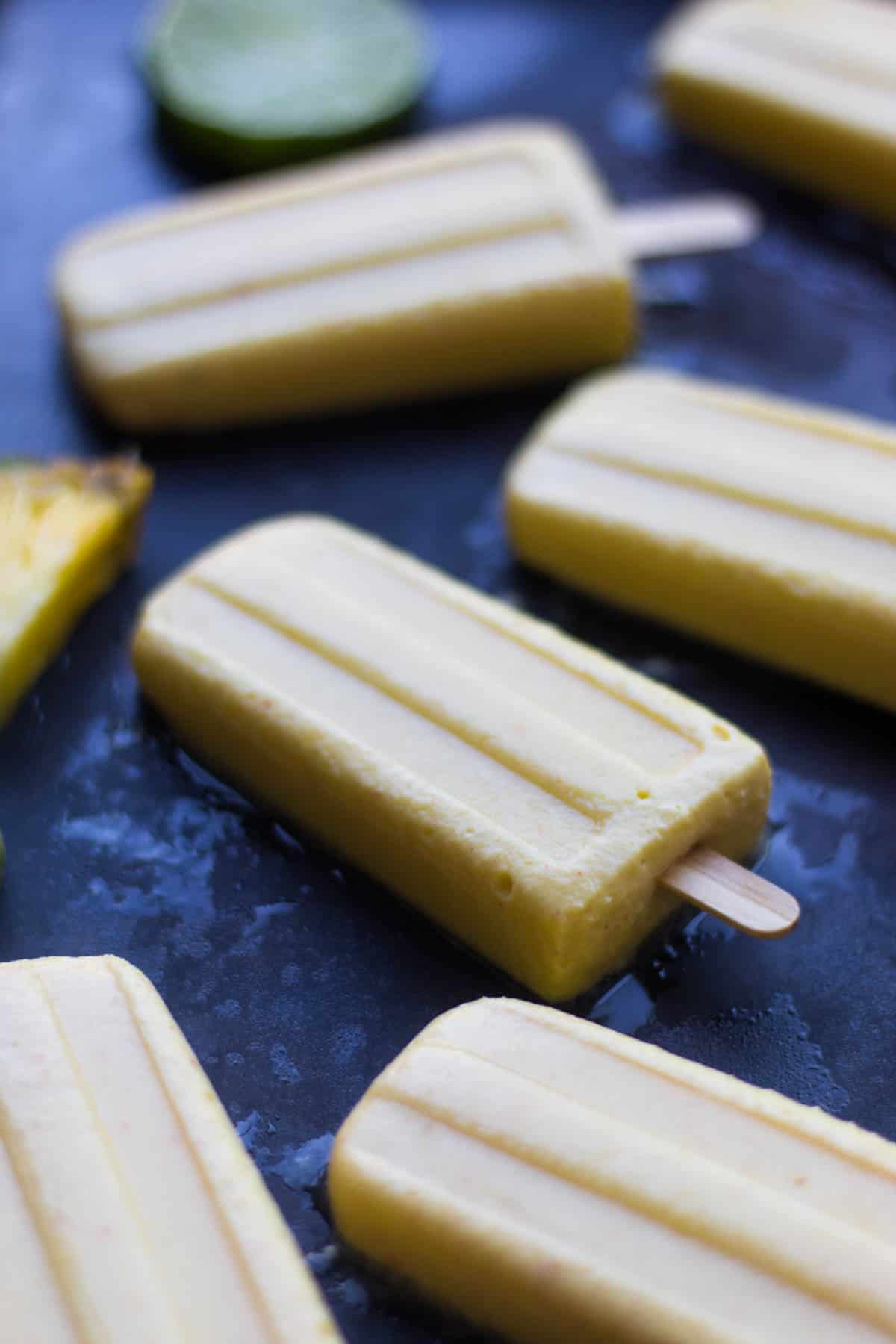 4 ingredient Pineapple Popsicles make an easy and healthy summertime treat. They are vegan, paleo, and sweetener free! - Eat the Gains