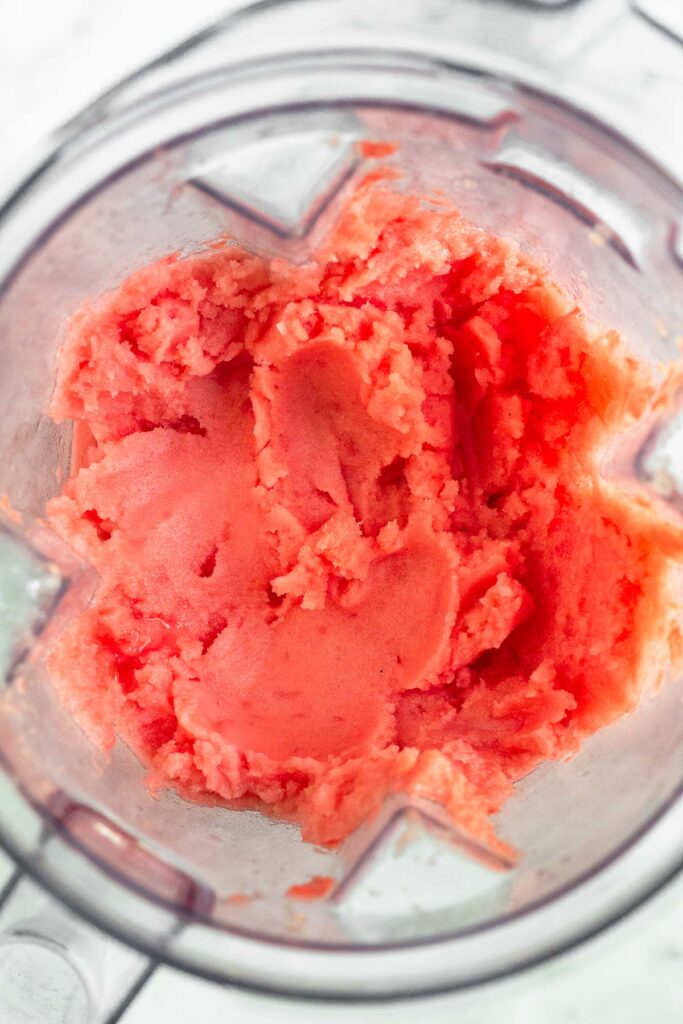 Overhead shot of frozen watermelon sorbet in a blender.
