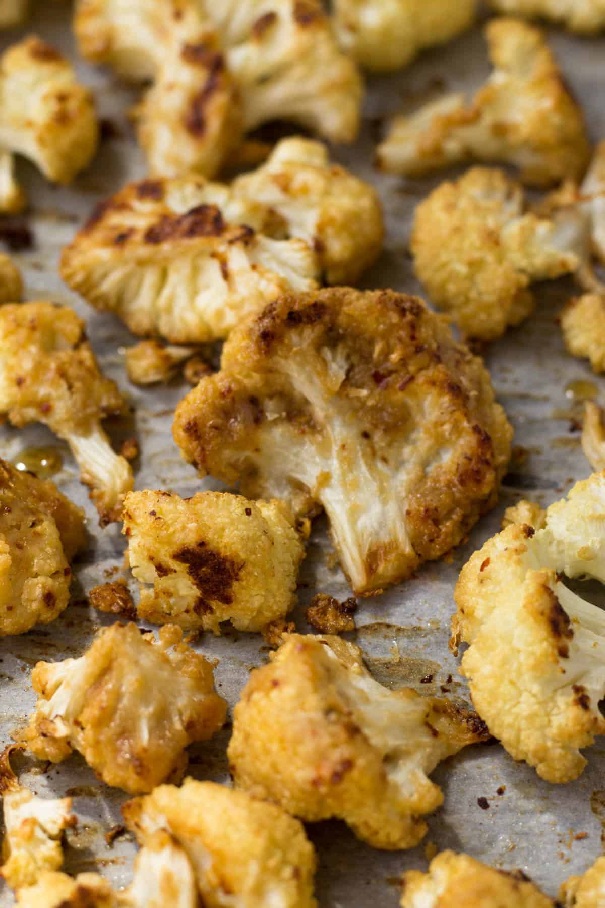 This vegan and paleo Maple Tahini Roasted Cauliflower make for an easy sweet and savory side dish - Eat the Gains