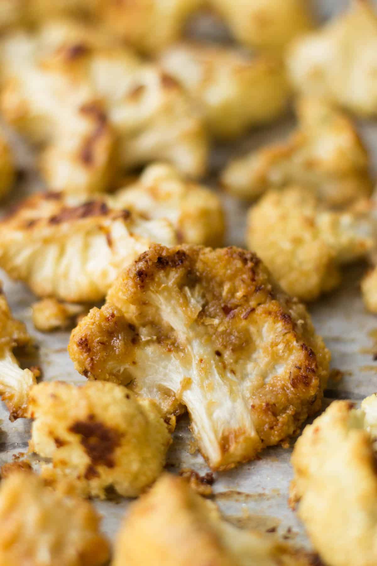 This vegan and paleo Maple Tahini Roasted Cauliflower make for an easy sweet and savory side dish - Eat the Gains