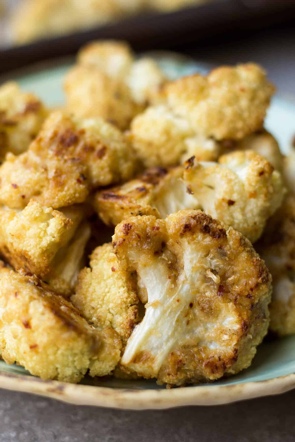 This vegan and paleo Maple Tahini Roasted Cauliflower make for an easy sweet and savory side dish - Eat the Gains