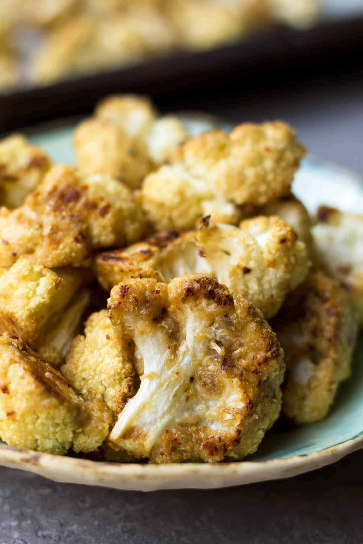 This vegan and paleo Maple Tahini Roasted Cauliflower make for an easy sweet and savory side dish - Eat the Gains