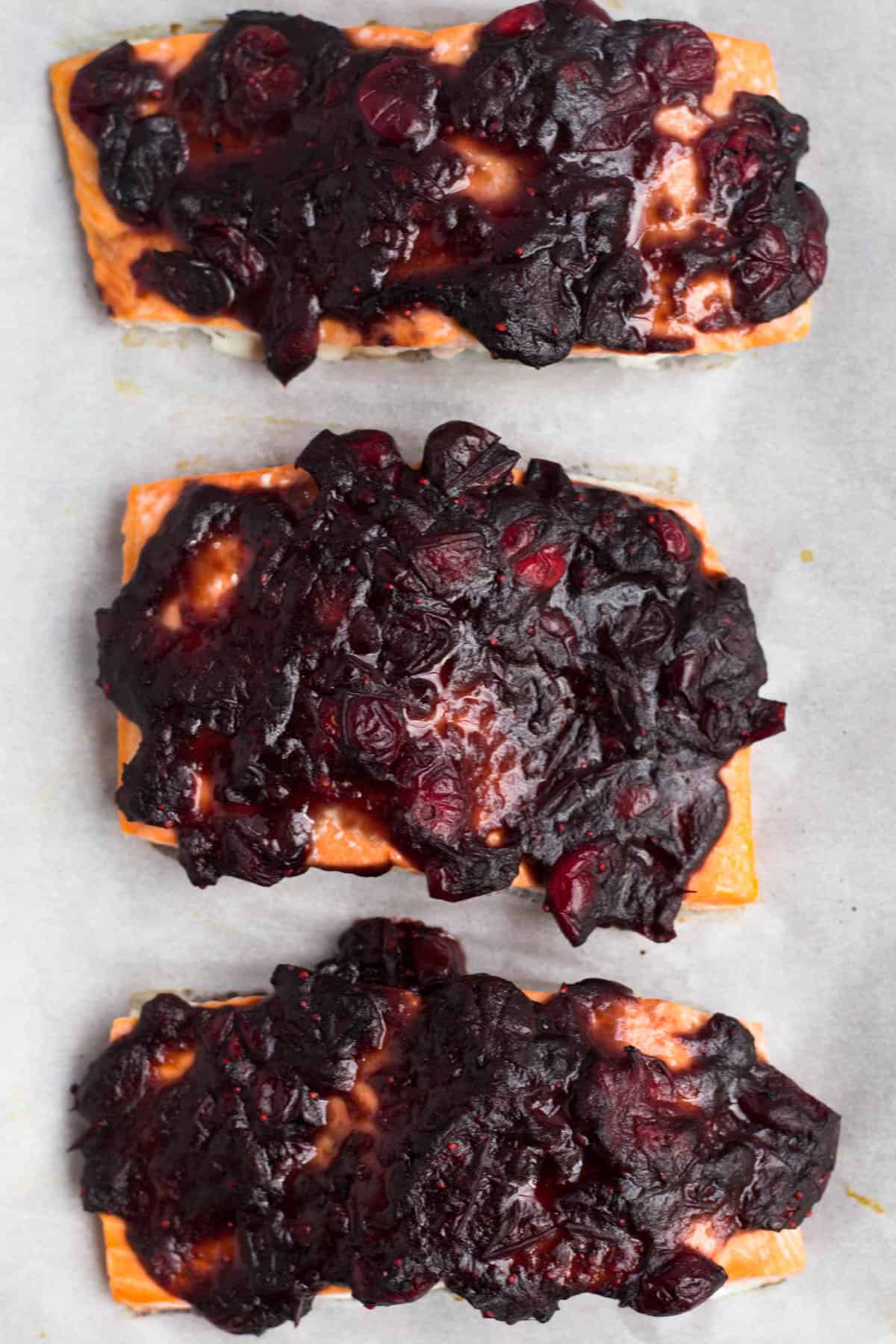 An easy and festive seafood dish, this Cranberry Balsamic Roasted Salmon takes 15 minutes, 4 ingredients, and is a crowd pleaser for the holidays - paleo and Whole30 approved! - Eat the Gains