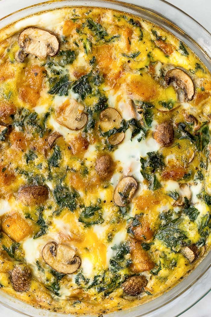 Overhead shot of a healthy pumpkin quiche with kale and mushrooms.