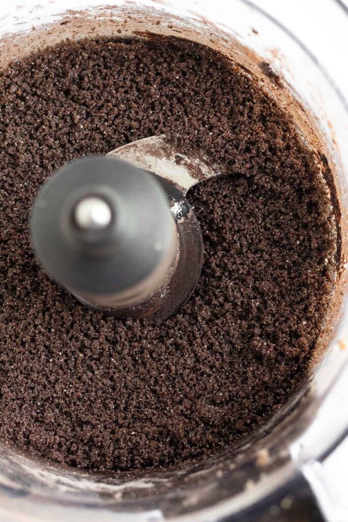 Overhead shot of crumbly chocolate batter in a food processor.