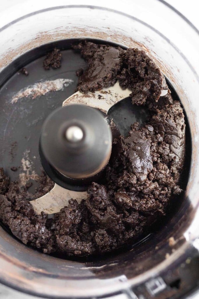Overhead shot of a sticky chocolate dough in a food processor.