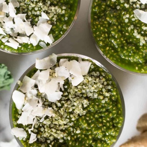 Overhead shot of 3 glasses with green juice chia pudding and toppings in them