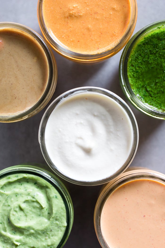 Overhead shot of a close up of 6 jars filled with different sauces in each.