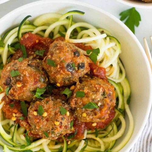 Bowl of supreme pizza meatballs with sauce over zucchini noodles