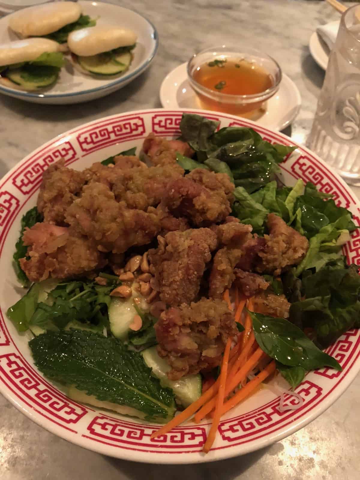 Noodle bowl with rice noodles, fresh herbs, veggies, and kaffir lime fried chicken