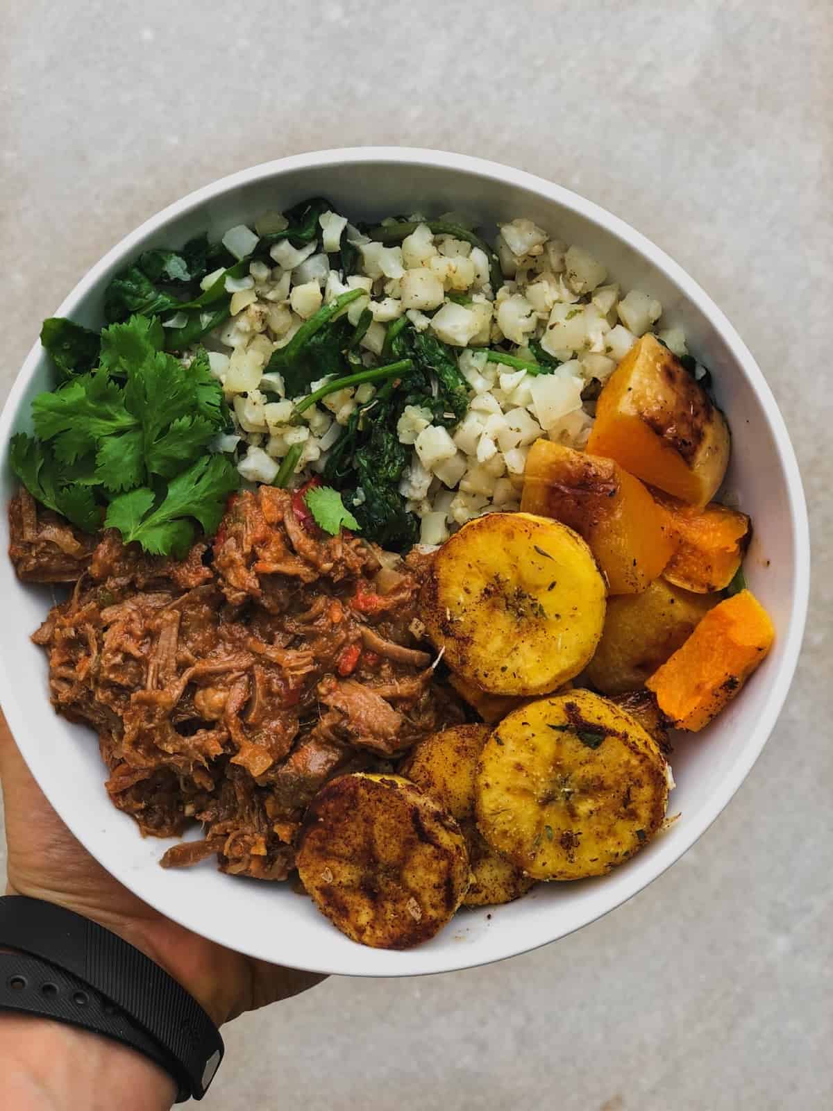 Bowl of ropa vieja with cauliflower rice, roasted butternut squash, and sautéed plantains