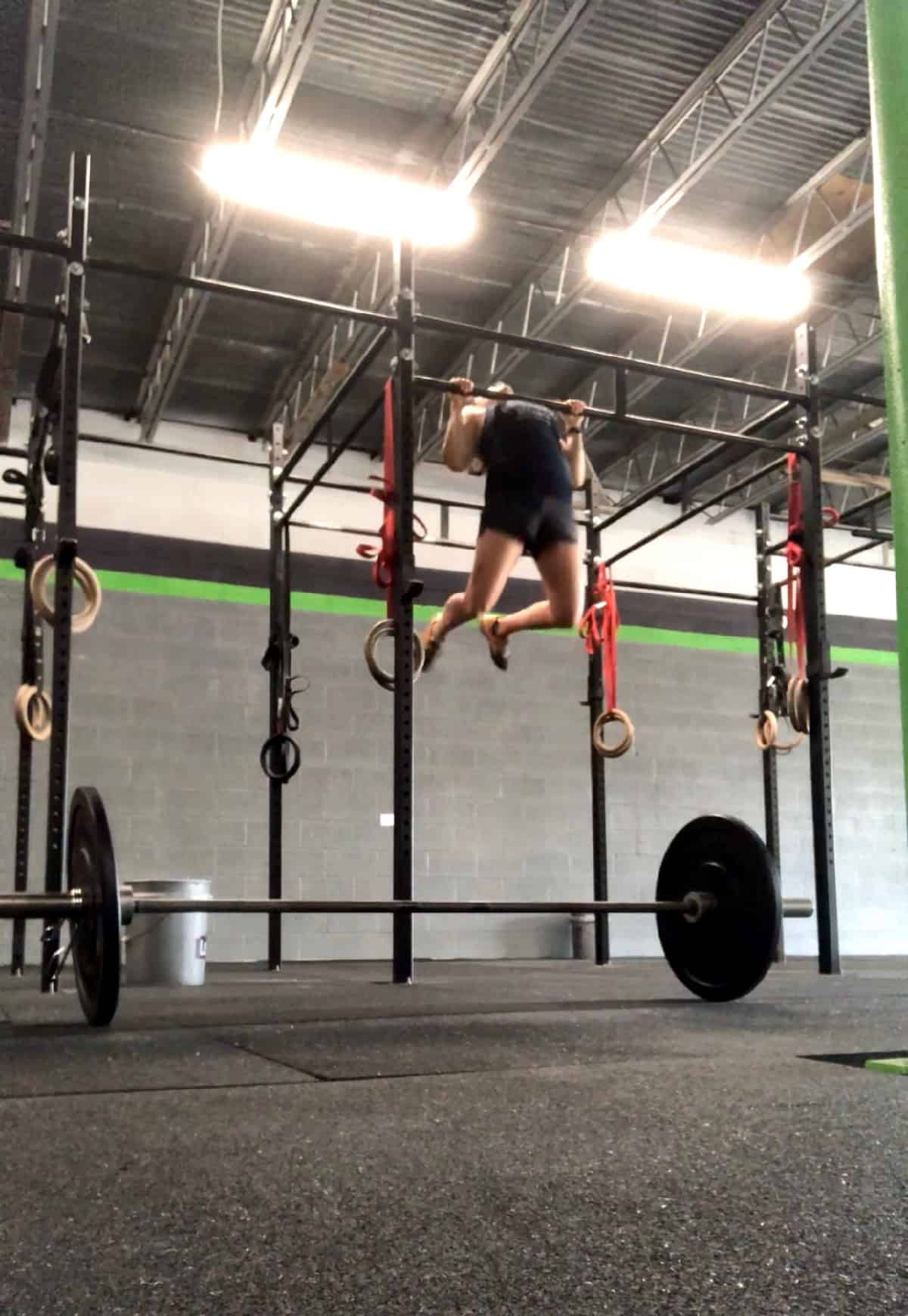 Girl doing a chest to bar pull-up