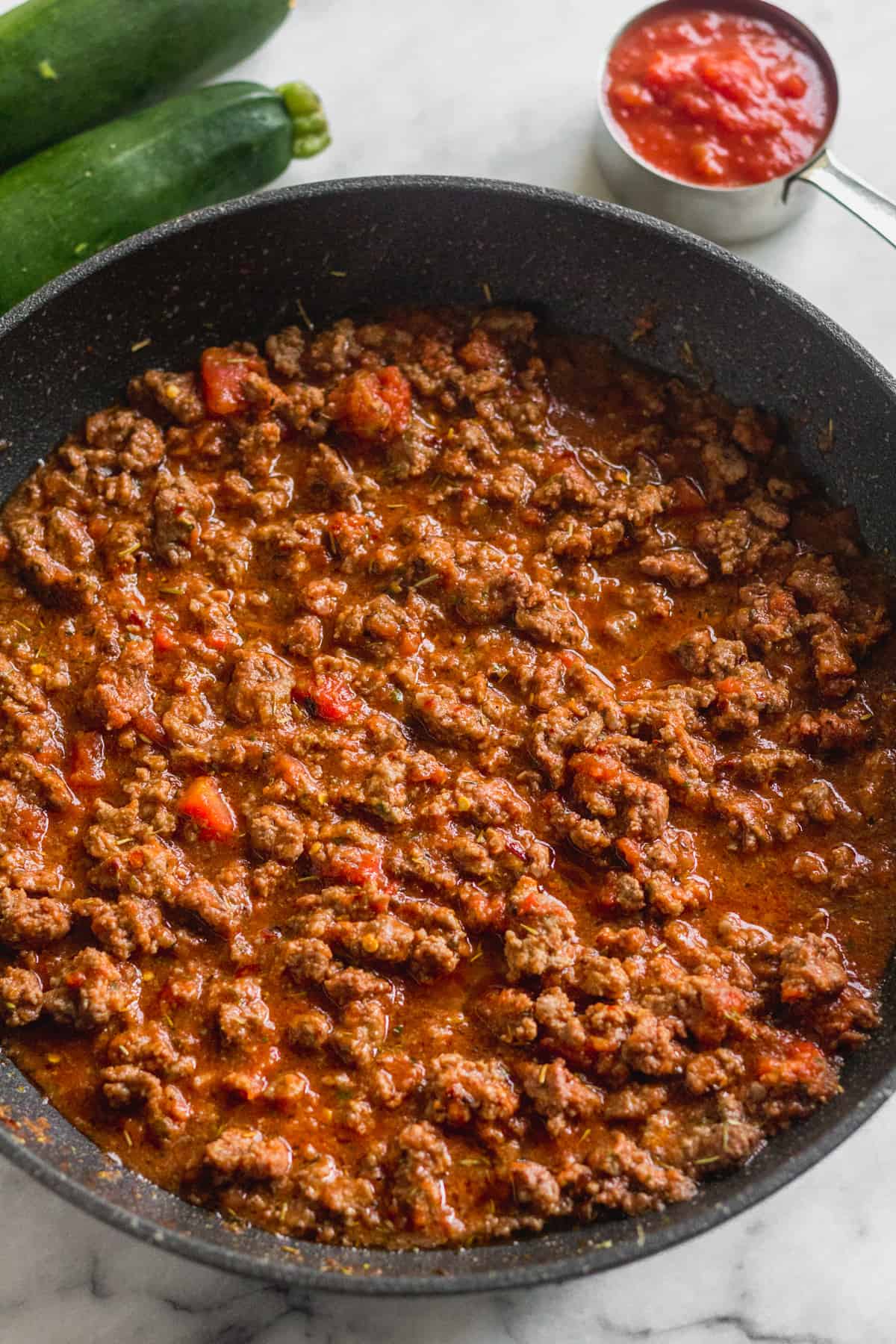 Pan filled with sautéed Italian ground beef, crushed tomatoes, and tomato sauce
