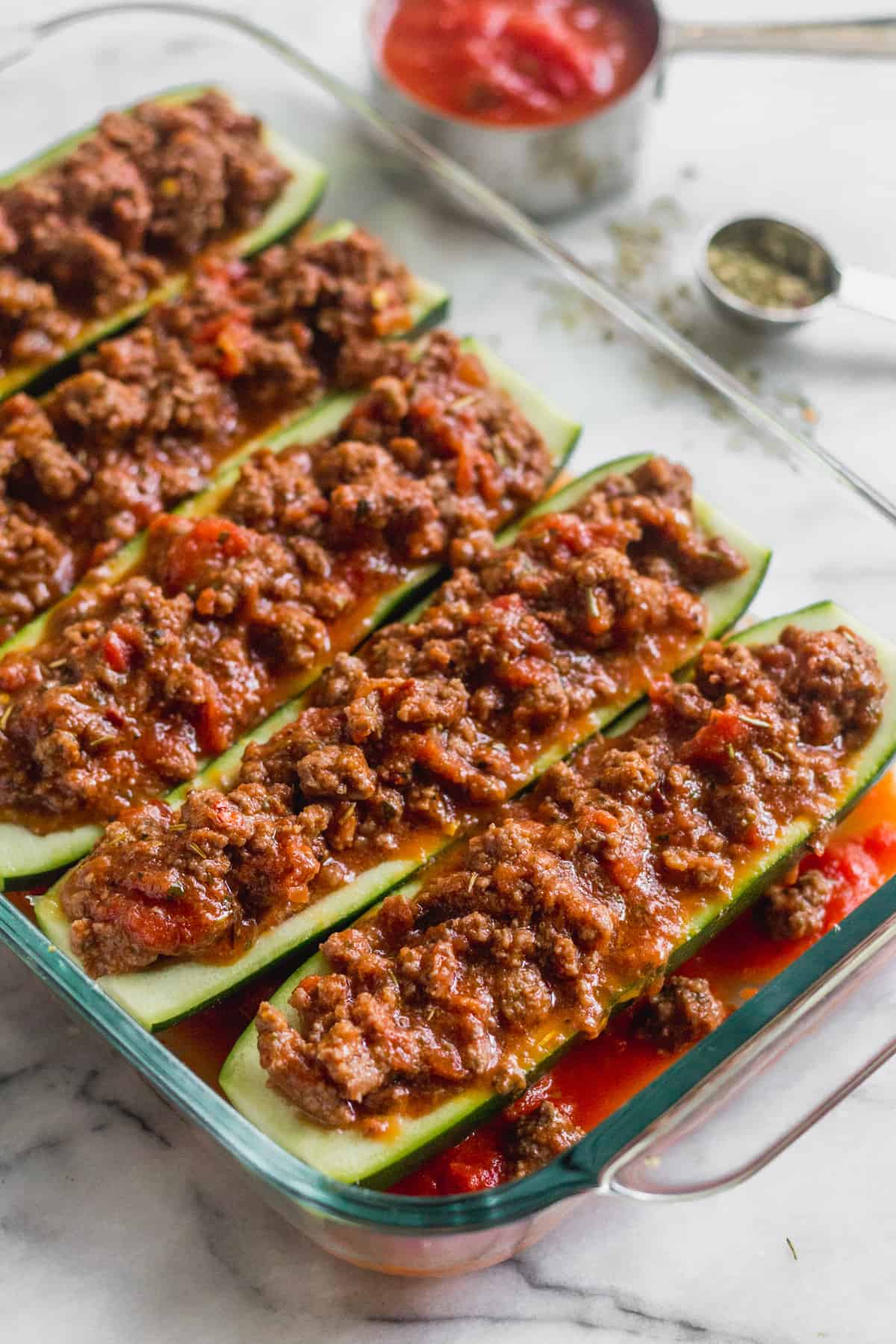 Zucchini boats stuffed with beef, tomatoes, and sauce before it is baked in the oven