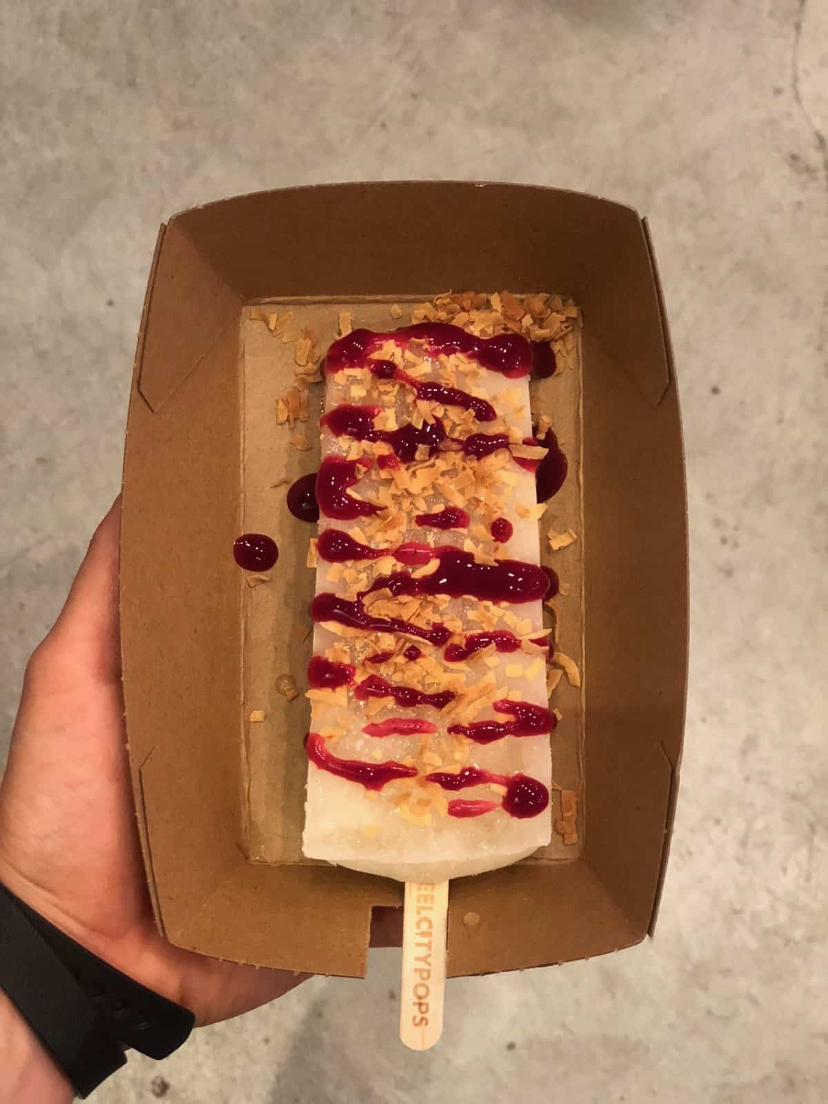 Steel City Popsicle covered with raspberry spread and toasted coconut