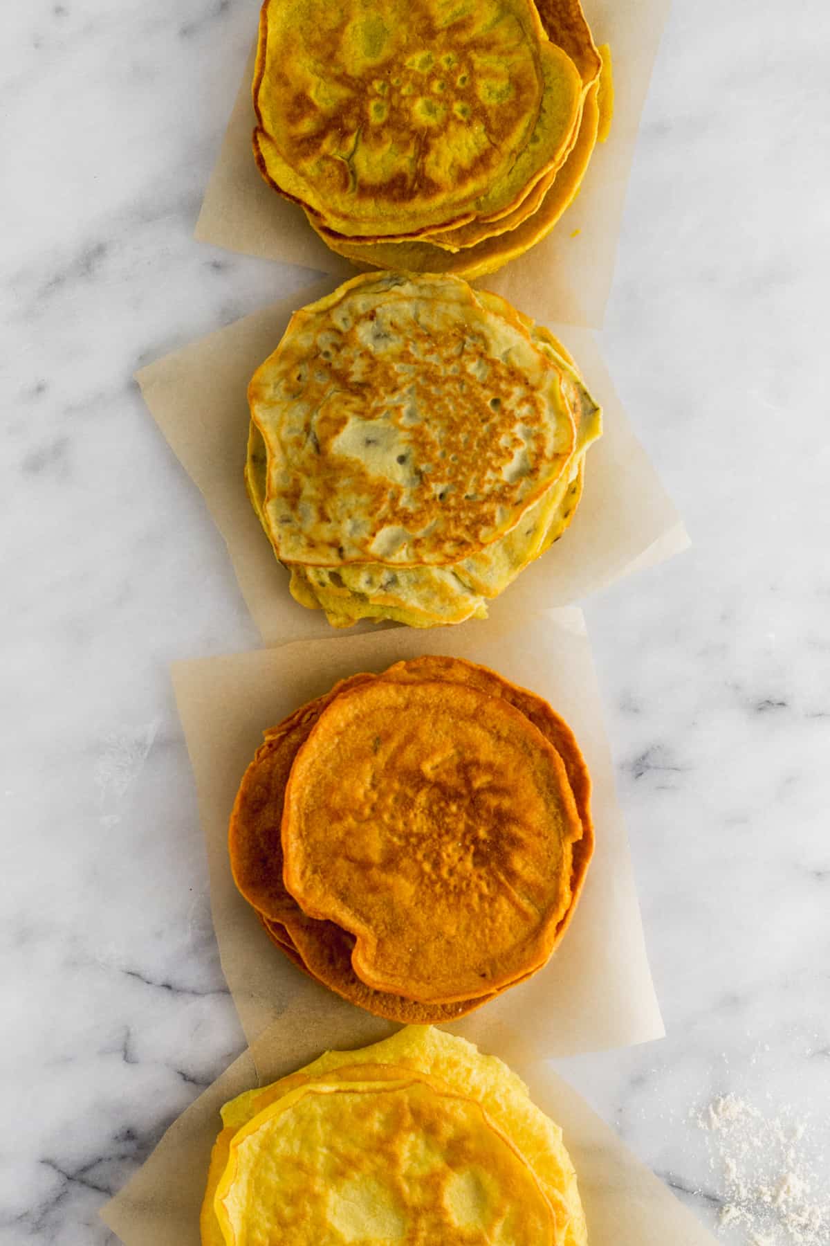 A line of 4 different kinds of paleo protein tortillas -turmeric, garlic & herb, paprika, and plain