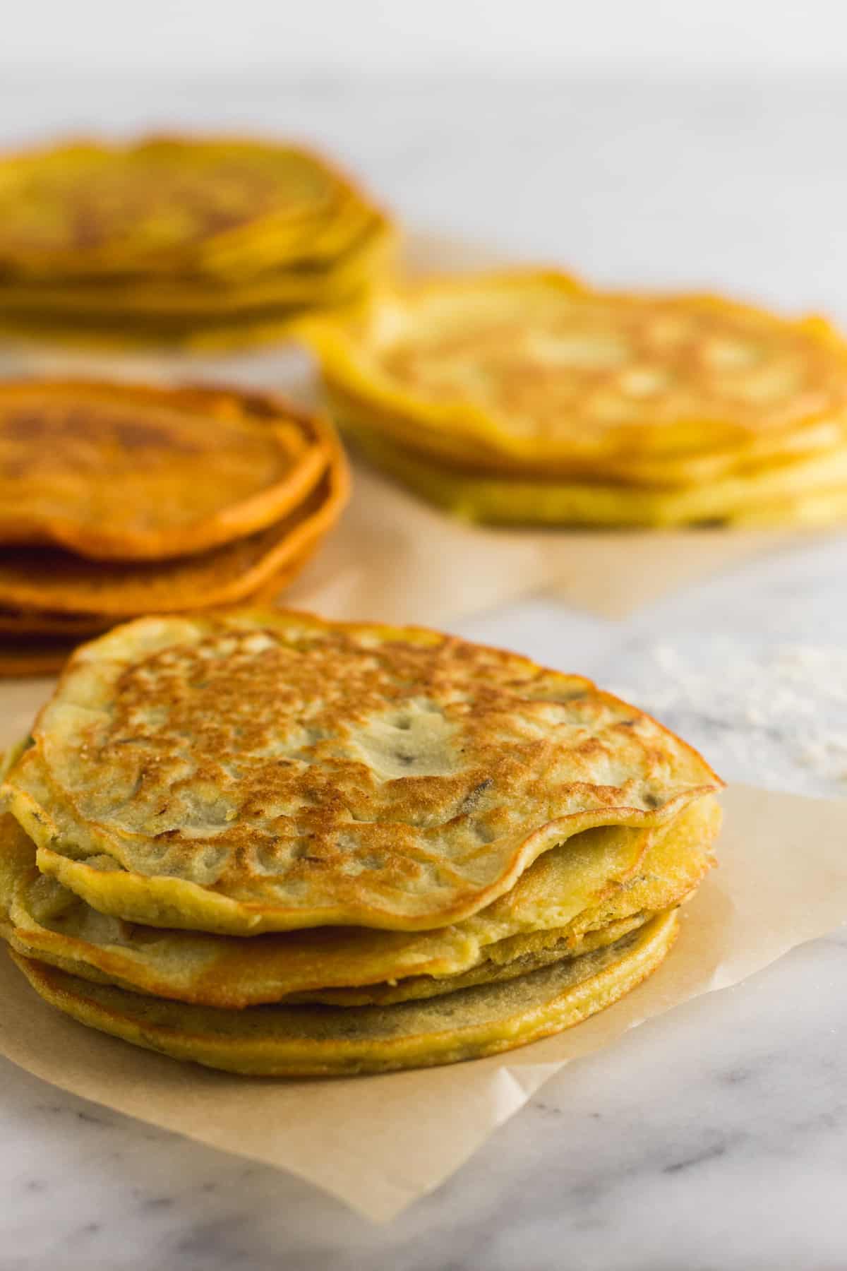 4 different kinds of paleo proteins on parchment paper on a white marble counter