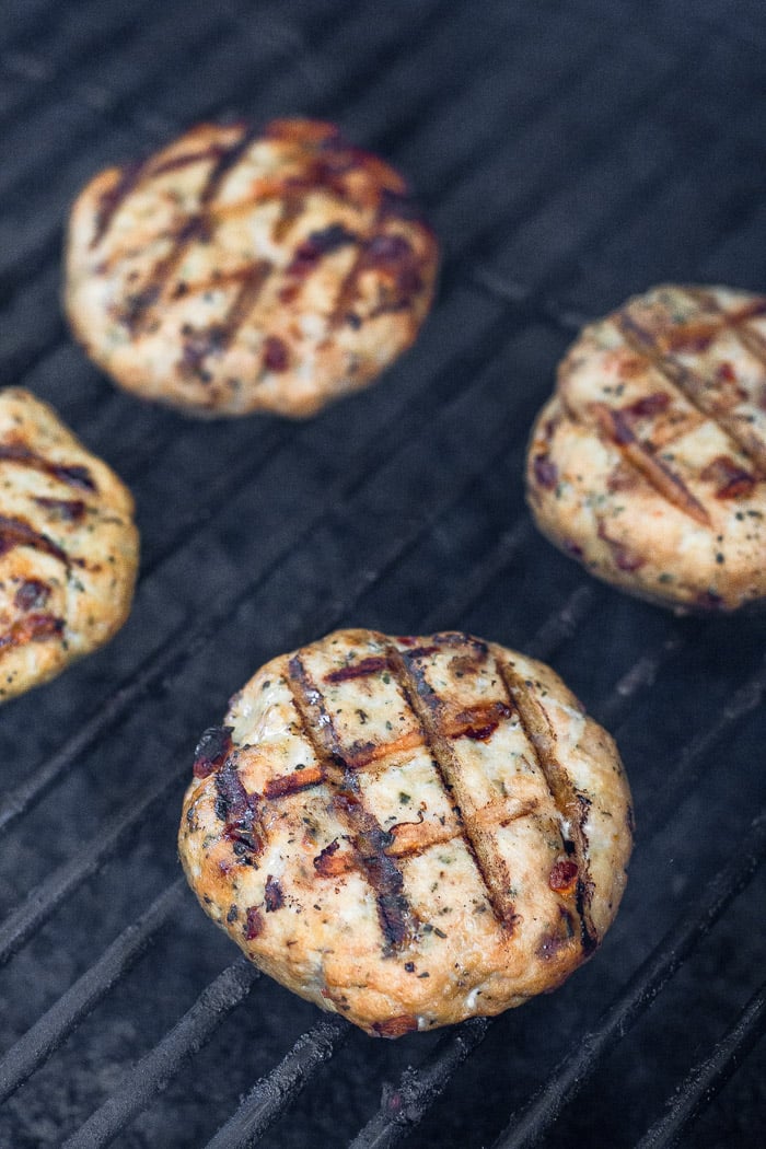 Grilled chicken burgers on a grill.