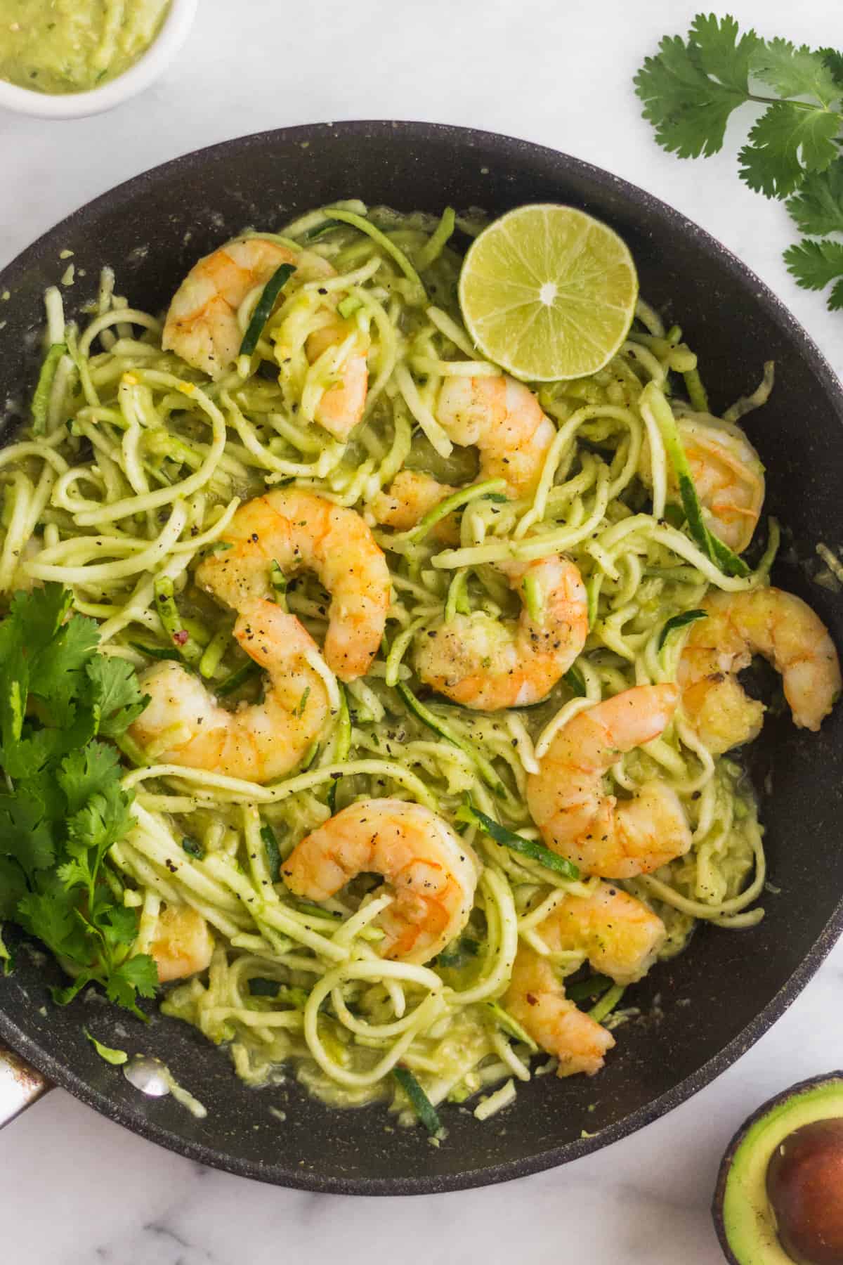 Large sauté pan filled Whole30 Tomatillo Salsa Shrimp Zucchini Noodles garnished with cilantro and lime