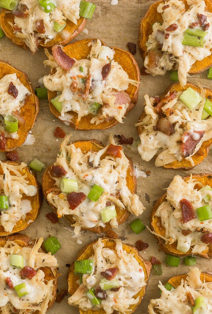 Chicken bacon ranch pizza on sweet potato rounds on a baking sheet.