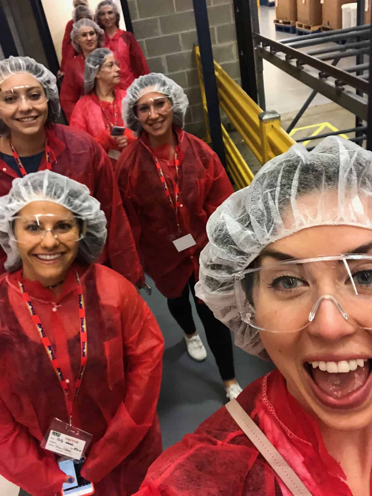 Group of girls inside the factory of a natural foods company in factory gear