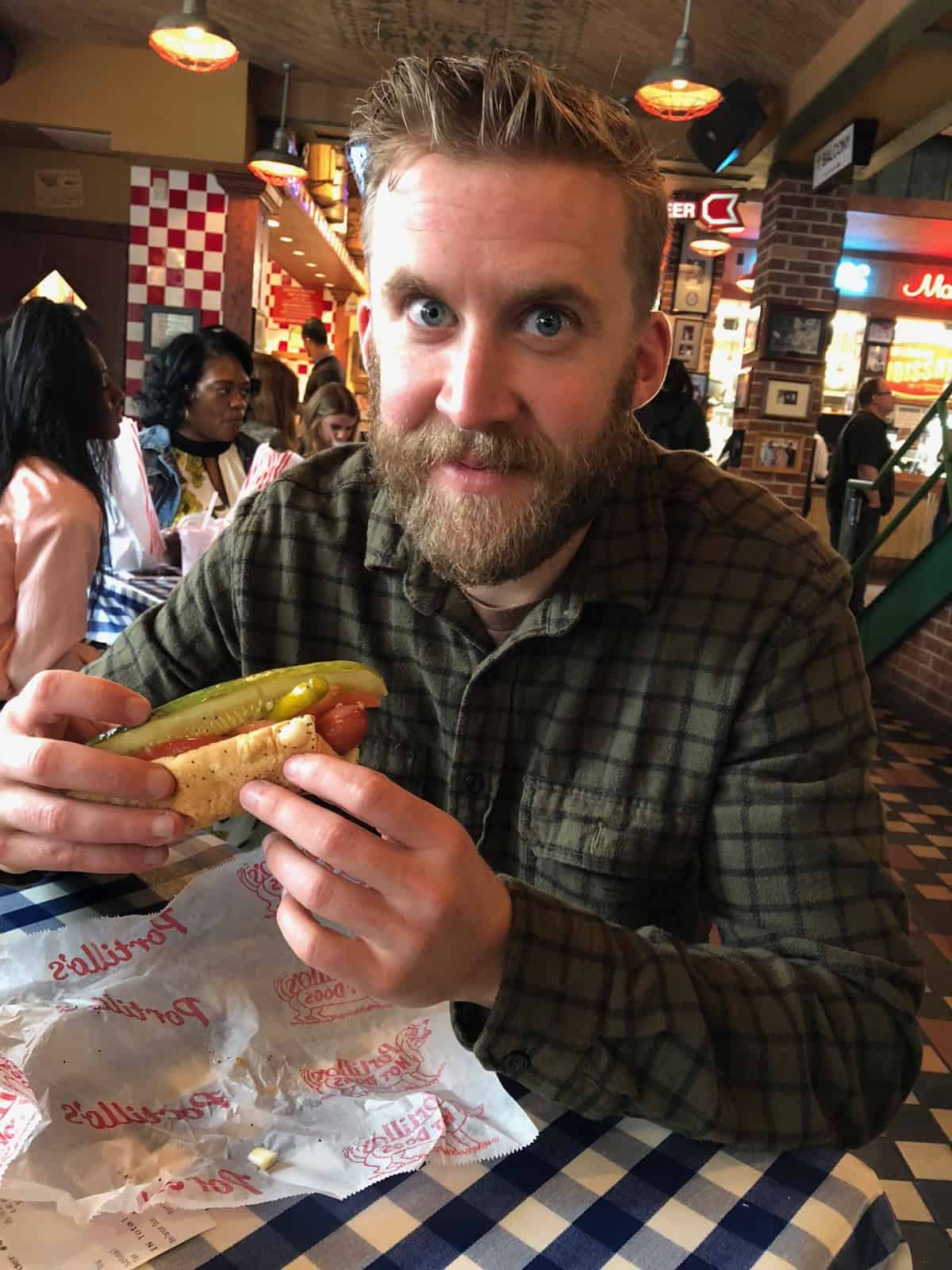 Man eating a Portillo's hot dog in Chicago, IL