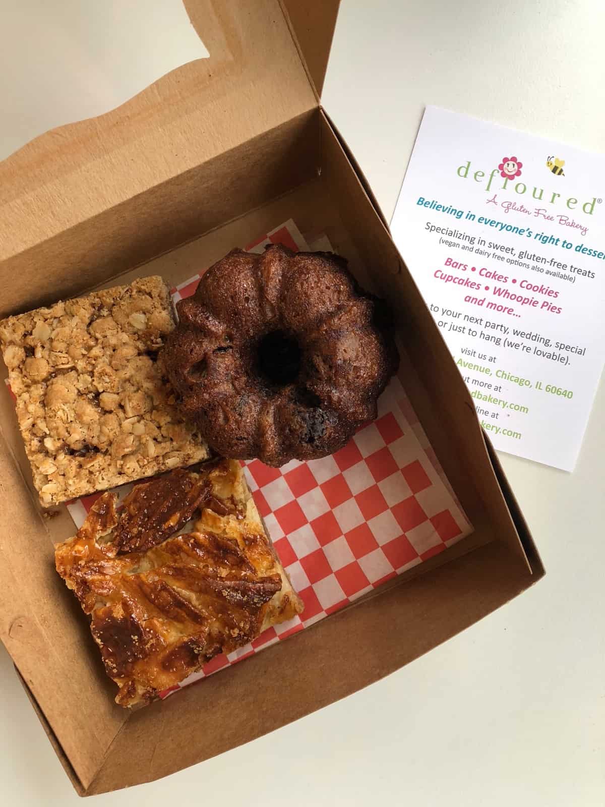 Box of gluten free baked goods - caramel oat bar, candy bar bake, and zucchini bread from Defloured in Chicago, IL