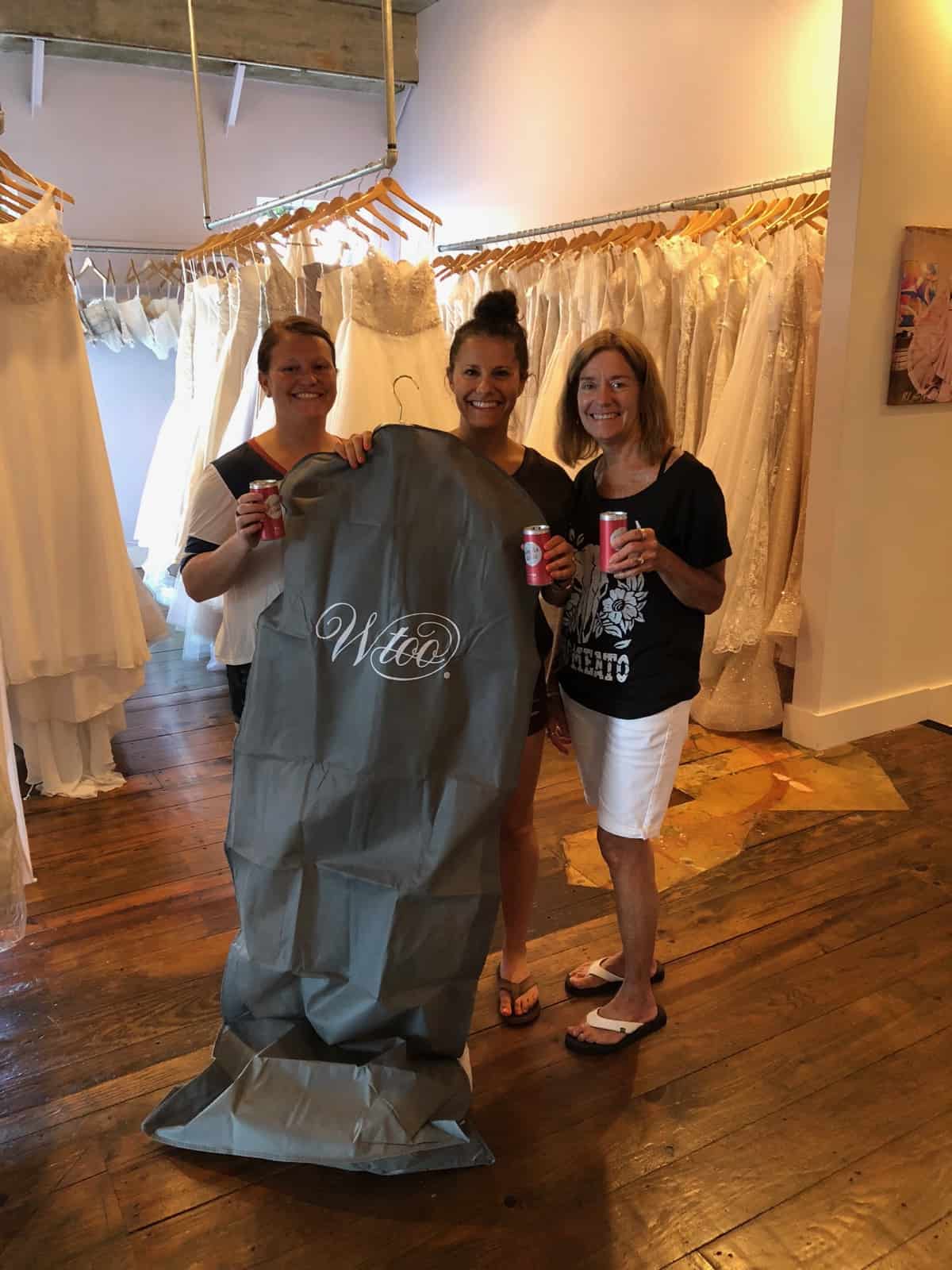 Picture of a girl and her mom and sister in a wedding dress shop