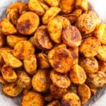 Crispy breakfast potatoes on a wooden plate lined with parchment paper.