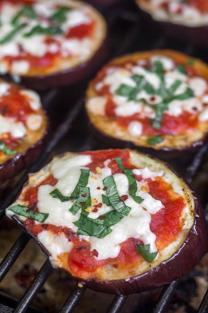 Grilled eggplant pizzas on a grill.