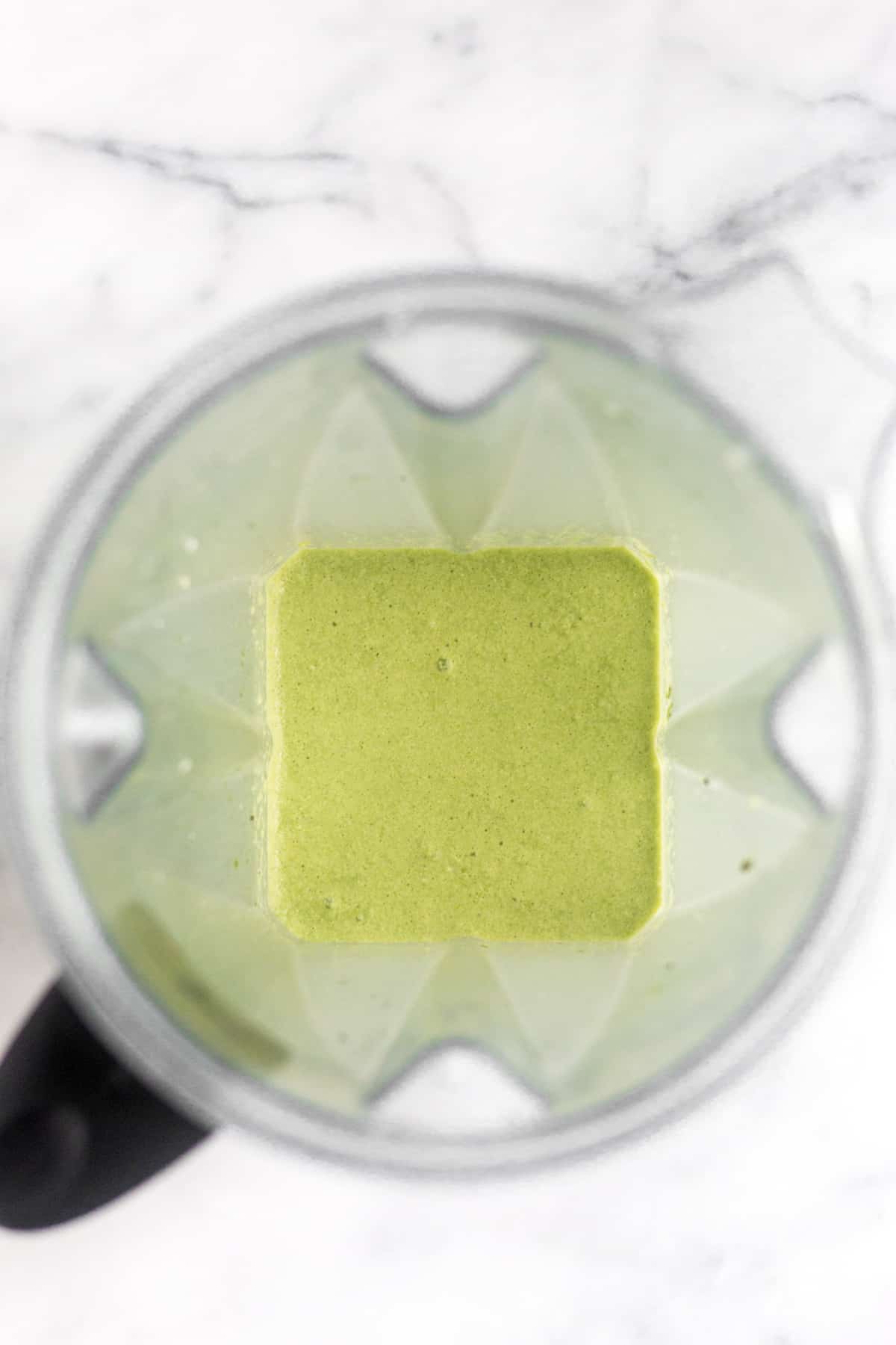 Blender filled with a blended iced matcha latte