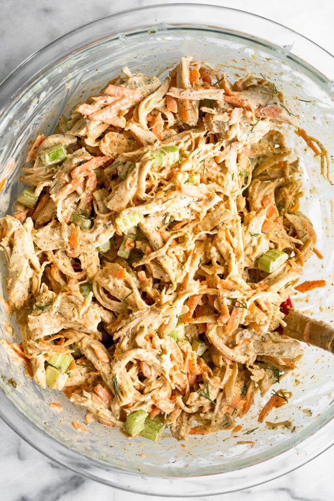 Overhead shot of buffalo ranch chicken salad in a large glass mixing bowl.