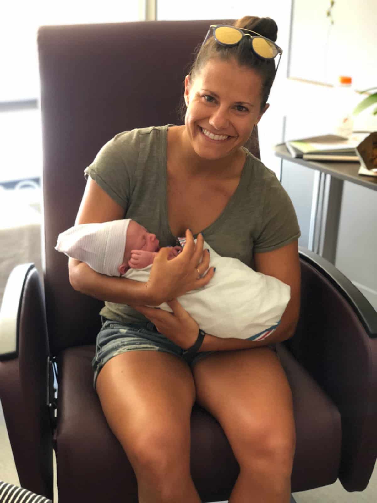 Girl holding a newborn baby in the hospital